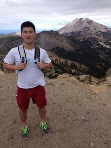 Picture of John B. with a backpack in front of a mountain trail